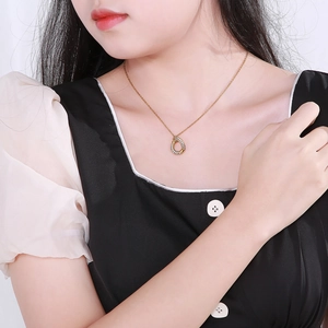 Gold-plated teardrop necklace with hollow diamond setting worn by model on black dress