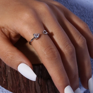 Detail of silver heart ring featuring a sparkling zircon stone and hollow heart design