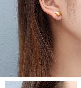 Close-up of model wearing 18k gold heart-shaped titanium steel stud earrings