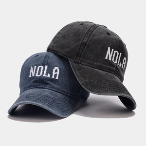 Close-up of vintage NOLA embroidered lettering on washed cotton baseball caps