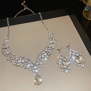 Close-up of sparkling teardrop crystal necklace and earrings set on display tray