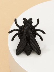 Detail shot of black insect cicada brooch with glossy finish and textured wings