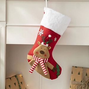 Close-up of red knitted Christmas stocking with 3D reindeer decor on fireplace