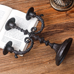 Vintage 3-arm black iron candle holder on rustic wooden desk for dining table decor