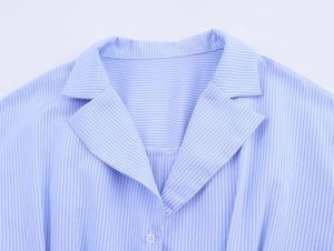 Close-up of the lapel collar and buttons on a light blue striped commuter shirt for women