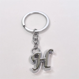 Polished silver metal letter H keychain with circular ring and chain on white background