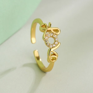 Gold plated LOVE geometric open ring with sparkling cubic zirconia on light background