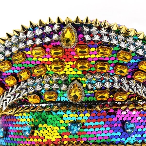 Macro detail of colorful sequins, metallic gold studs, and vibrant rhinestones on a flat cap