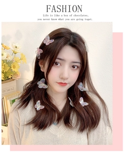 Close-up of colorful iridescent butterfly hair clips styled on model's hair with floral decor