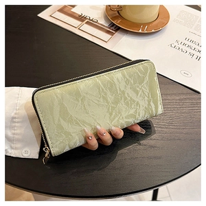 Light green pleated velvet long wallet with zipper closure held in a stylish setting