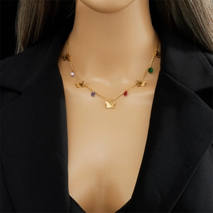Goldene Schmetterlingskette mit bunten Edelsteinperlen getragen von einem Model im Blazer
