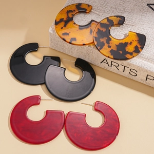 Three pairs of acrylic C-shaped hoop earrings in tortoiseshell, black, and marble red patterns