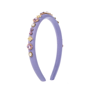 Détail du serre-tête en tricot violet avec cristaux en cœur et ornements en perles