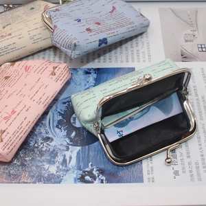 Detail of vintage canvas coin purses with dragonfly print and metal clasp closure