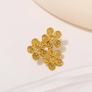 Elegant gold flower ring with micro-pave diamonds on minimalist stone and silk background