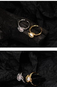 Detailed macro of silver and gold branch texture rings with opal stone on dark wood