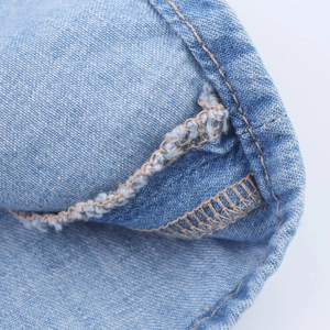 Détail de la double couture et de la finition des bords du combishort en denim