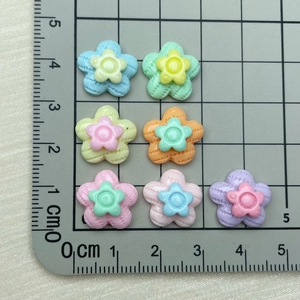 Mini pastel resin flower charms for nails and crafts shown next to a ruler for scale