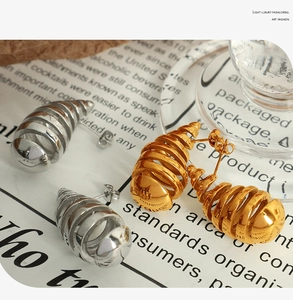 Detailed view of luxury gold and silver spiral stud earrings with elegant metallic texture