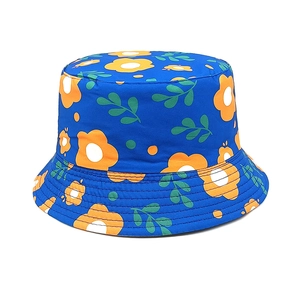 Détail d'un chapeau bob en coton bleu roi avec des motifs floraux orange et feuilles vertes