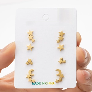 Detail of four pairs of gold stainless steel star and moon stud earrings on a display card