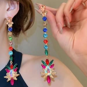 Close-up of long bohemian style drop earrings with colorful crystals on model