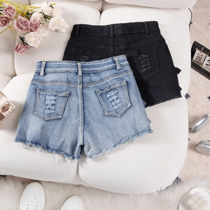 Detail view of denim shorts featuring distressed back pockets and raw frayed edges