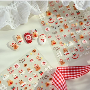 Detail of Christmas nail art stickers featuring 3D cartoon bear, reindeer, and snowman motifs