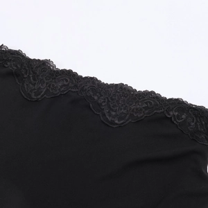 Détail de la dentelle noire élégante et du tissu soyeux sur une robe à une épaule