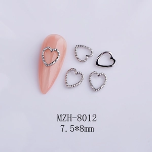Macro detail of 7.5x8mm silver hollow heart nail charms with textured and smooth finishes