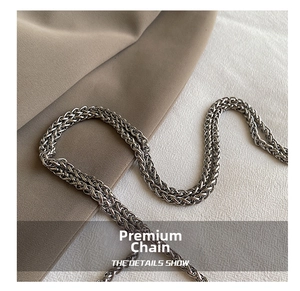 Macro shot of high-quality silver braided metal chain strap on premium fabric background