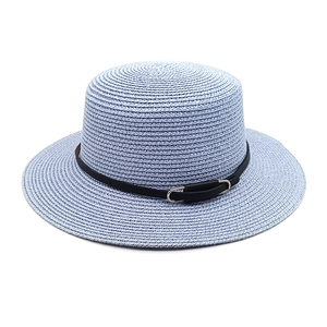 Détail d'un chapeau de paille bleu clair avec sangle en cuir noir et boucle argent