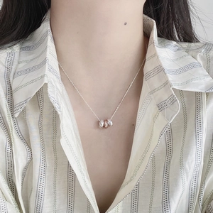 Detail of S925 silver necklace with three interlocking rings in silver and rose gold