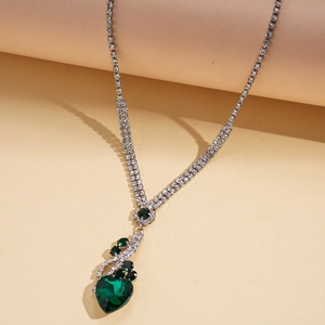 Detail showing heart-shaped green crystal pendant with rhinestones on silver chain