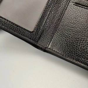 Primer plano de una cartera de hombre en cuero negro con ranuras y ventana para fotos