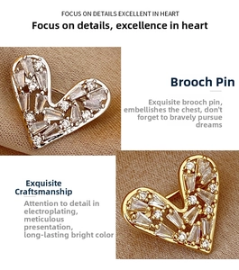 Detailed view of gold heart brooch with sparkling zircons on textured brown fabric