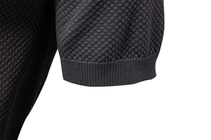 Detail of dark gray honeycomb knit texture and ribbed cuffs on the polo shirt