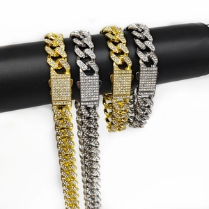 Detail of 12.5mm iced out Cuban link chains in gold and silver on a jewelry display