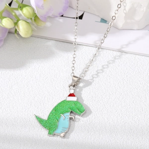 Detailed view of green glitter dinosaur pendant wearing a festive red Christmas hat