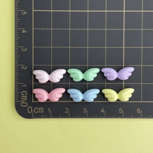 Detailed view of colorful 2cm resin wing charms for DIY nail art and jewelry making
