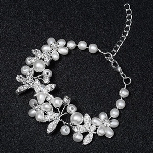 Detail of silver stretch bracelet with pearls, rhinestone flowers and adjustable clasp