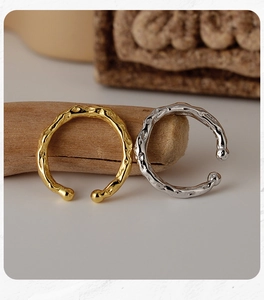 Detail view of gold and silver S925 sterling silver ear cuffs with hammered texture design