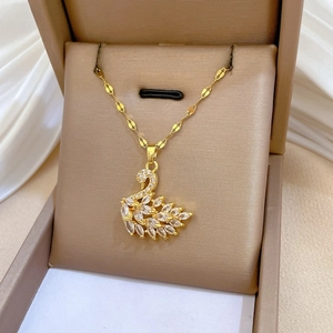 Macro detail of a sparkling swan pendant necklace with white zircons in a golden gift box
