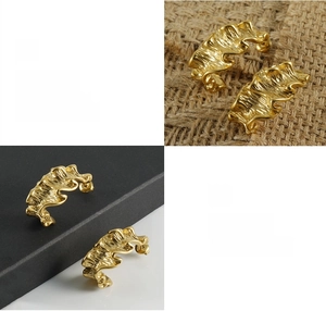 Detailed close-up showing high-polish gold plating and wave texture on titanium steel earrings