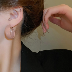 Close-up of model wearing C-shaped chunky nude pink matte resin hoop earrings