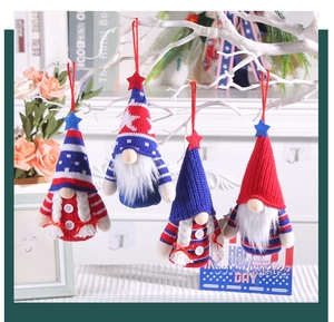 Close-up of four knitted Independence Day gnomes with stars and stripes on white branches