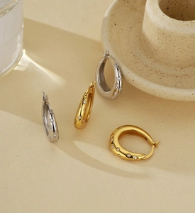Close-up of elegant gold and silver star-shaped hoop earrings with sparkling rhinestones
