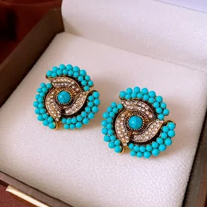 Vintage floral stud earrings with turquoise beads, sparkling rhinestones, and antique gold finish