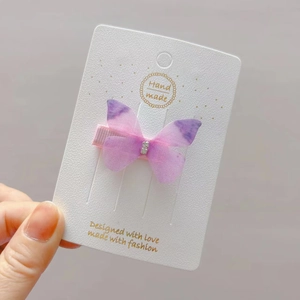 Detail of a purple and pink butterfly hair clip with rhinestones for little girls