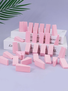 Macro shot of pink non-latex triangle makeup sponges displayed on creative props